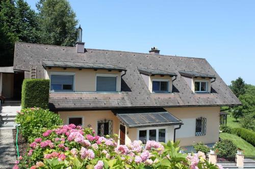 a house with pink flowers in front of it at Appartement Ferienwohnung Bilek in Gmunden