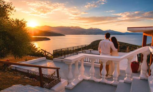 a man and a woman standing on a balcony watching the sunset at Istron Homes in Istro