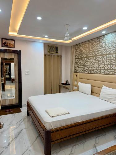 a bedroom with a large bed and a mirror at Hotel Umang in Sītāmarhi