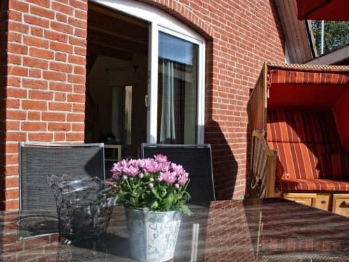 a vase of flowers sitting on a glass table at Beeck - FeWo mit Terrasse und Strandkorb in Oeversee
