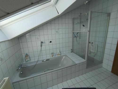 a bathroom with a tub and a glass shower at Ferienwohnung Zöller Villmar in Villmar