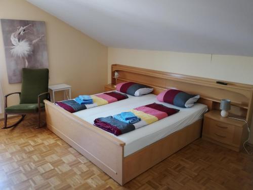 a bedroom with two beds and a green chair at Ferienwohnung Zöller Villmar in Villmar
