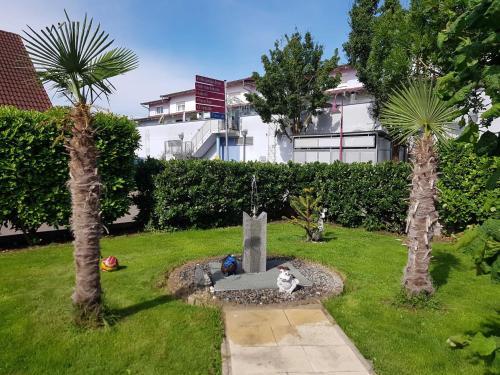 a garden with a monument in the middle of two palm trees at Gästehaus Schwien in Rust