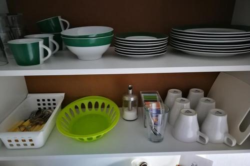 a shelf with plates and cups and dishes on it at Gästezimmer Sieg in Rust