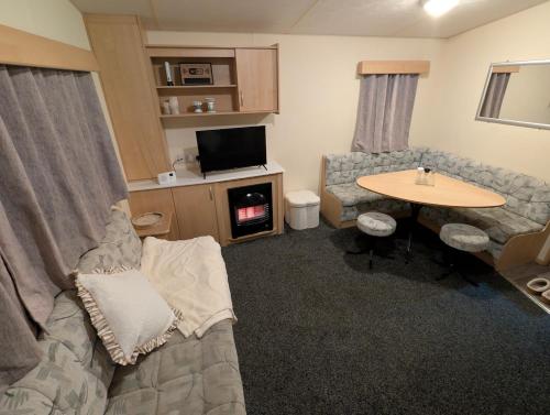 a living room with a couch and a table at Shore&Meadow Holiday Lets - Luxury 8 berth caravan at Regent Bay in Morecambe