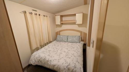 a small bedroom with a bed in a small room at Shore&Meadow Holiday Lets - Luxury 8 berth caravan at Regent Bay in Morecambe