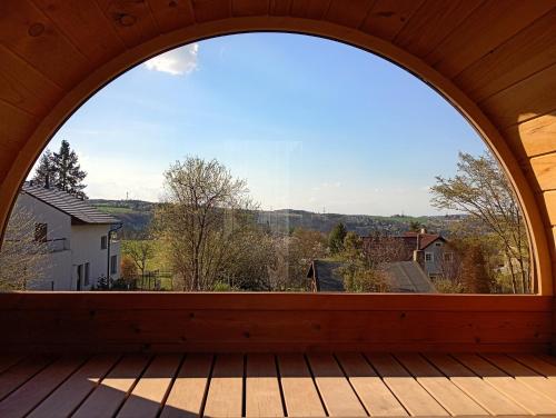 an arched window on a wooden deck with a view at Chata Budka - parties not allowed in Hradišťko