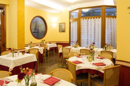 a restaurant with white tables and chairs and a mirror at Pensione Al Pescatore in Termoli