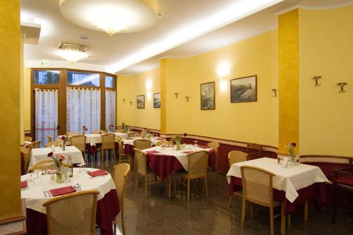 a dining room with tables and chairs and yellow walls at Pensione Al Pescatore in Termoli