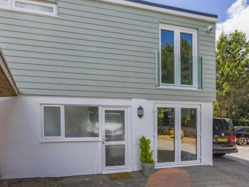 a white house with windows and a garage at Kingsleys Lodge in Barnstaple