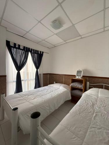 a bedroom with two beds and a window at Casa YRIGOYEN in Junín