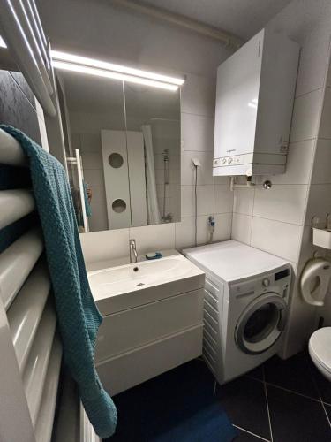 a bathroom with a sink and a washing machine at Apartmani Sime in Savar