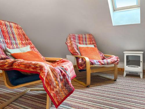 two chairs with blankets sitting in a room at Bothy Cottage - Uk51350 in Peebles