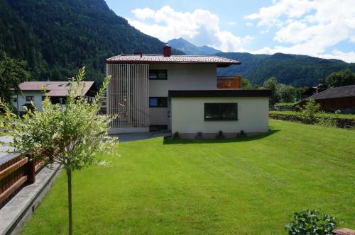 a house with a green lawn in front of it at Der Steinadler in Umhausen
