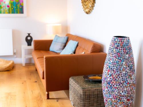 a living room with a brown couch with blue pillows at Sunset Beach - Uk42994 in Woolacombe