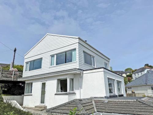 a white house with windows on top of stairs at Whitestones in Saint Mawes