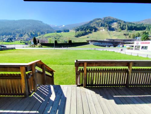 two benches on a deck with a view of a field at Residence Mariagrazia - Kärnten Card im Sommer inklusive in Bad Kleinkirchheim