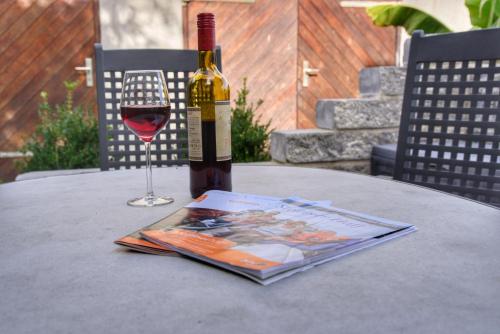 a bottle of wine on a table with a magazine and a glass at Haff-Ostseeferienhausapartment Erdgeschoß in Mönkebude