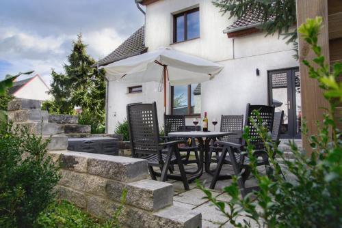 a patio with a table and chairs and an umbrella at Haff-Ostseeferienhausapartment Erdgeschoß in Mönkebude