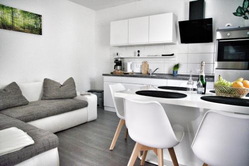 a kitchen and living room with a table and a couch at Haff-Ostseeferienhaus Nebengebäude in Mönkebude
