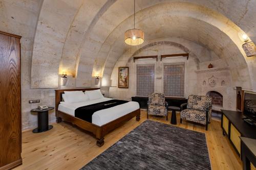 a bedroom with a bed and a fireplace at Stone House Cave Hotel in Göreme