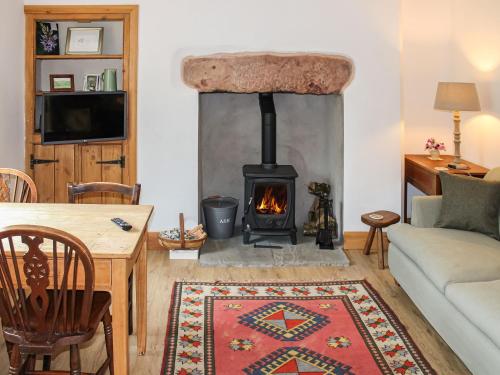 a living room with a wood stove in a room at Smardale Cottage in Kirkby Stephen