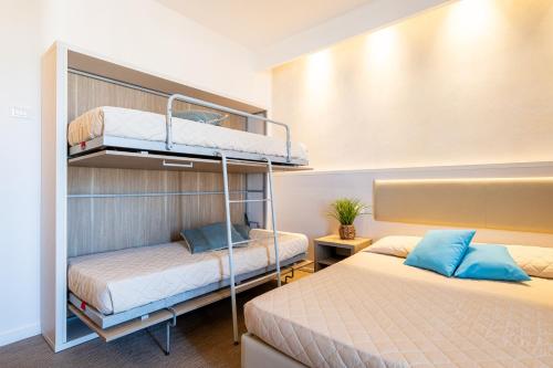 two bunk beds in a room with two beds at Villaggio Poseidone Beach Resort - Hotel in Torre San Giovanni Ugento
