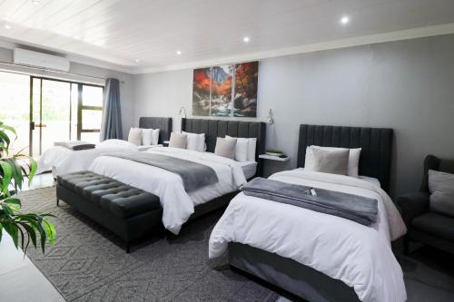 a hotel room with four beds and a couch at African Sands Guesthouse in Bloemfontein