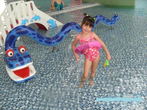 a little girl is playing in a water park at Oázis Apartman in Harkány