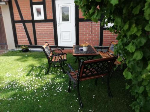 three chairs and a table in a yard at Bungalow Hartmann in Lüssow