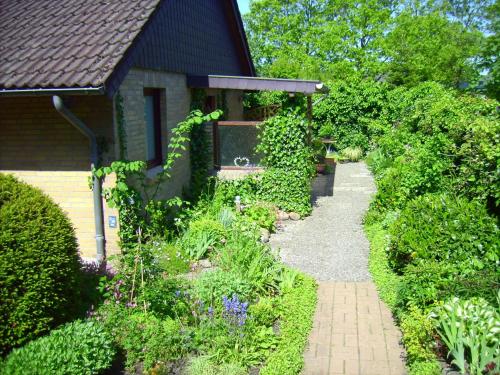 a garden with a path leading to a house at Ferienwohnung Diena - Unterkunft mit toller Ausstattung und zwei Terrassen in Tarp