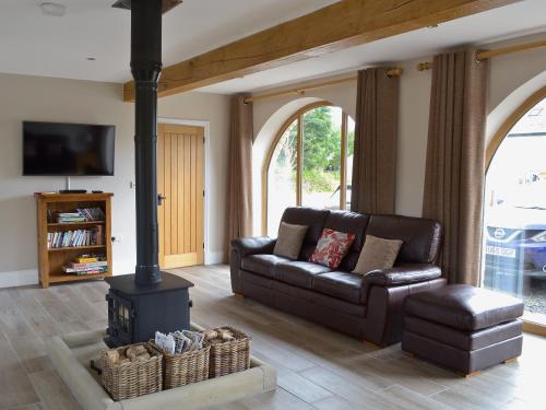 a living room with a leather couch and a wood stove at The Granary in Pendleton