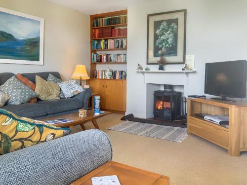 a living room with a couch and a fire place at Garrique Cottage in Kippen