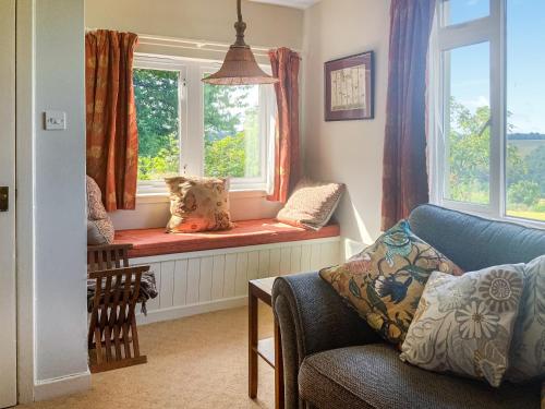 a living room with a window seat with a couch at Garrique Cottage in Kippen