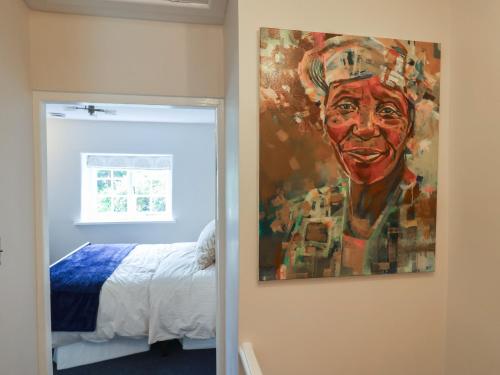 a painting of a man hanging on a wall next to a bedroom at 6 Bedford Place in Bridport