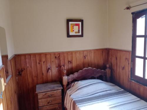 a bedroom with a bed and a wooden wall at K&M descanso y excursiones in Fiambalá
