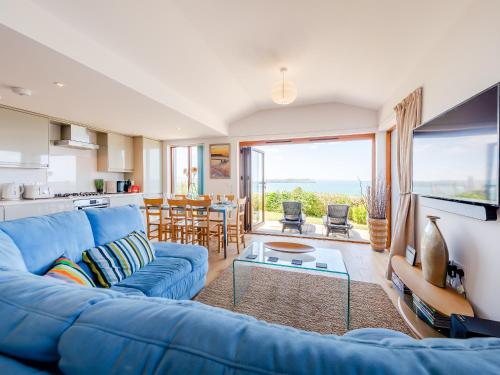 a living room with a blue couch and a kitchen at Beachbreak - Uk42996 in Woolacombe