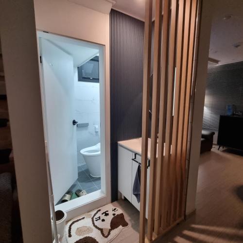 a bathroom with a toilet and a large mirror at YYStay 감성 루프탑 in Seoul
