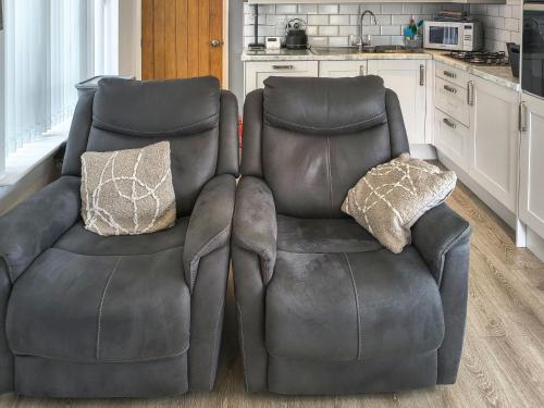 two leather chairs sitting next to each other in a kitchen at Willow Tree Farm in Sutton on Sea