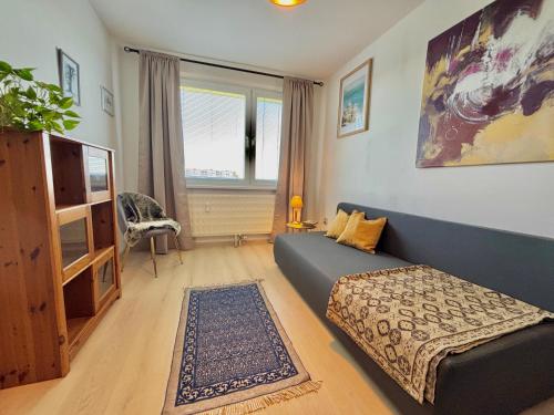 a living room with a blue couch and a tv at Samaria Central Apartment in Šamorín
