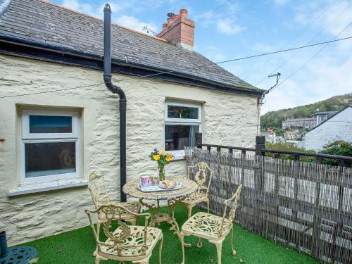 a patio with a table and chairs in front of a house at Gypsett in Polruan