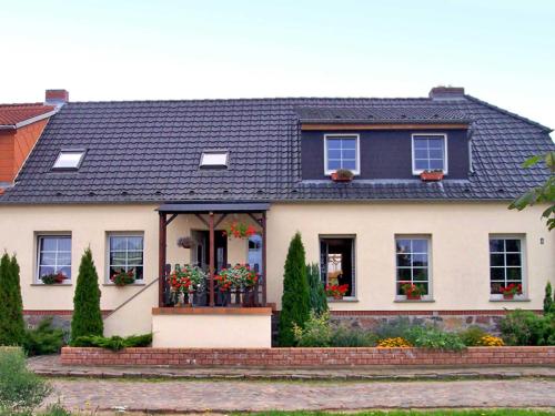 ein weißes Haus mit schwarzem Dach in der Unterkunft Ferienwohnung mit großem Balkon in Bömitz in Bömitz