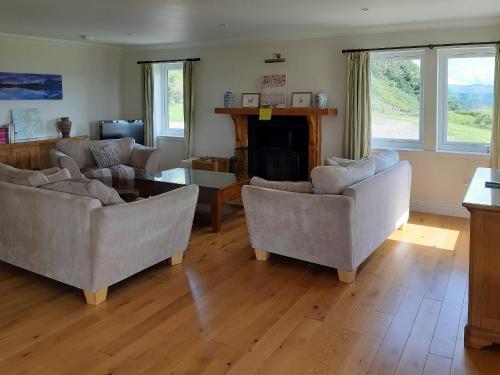 a living room with two couches and a fireplace at Degnish Farmhouse - Swwu in Kilmelfort