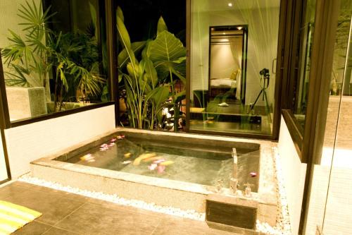 a jacuzzi tub in the middle of a room at Baan Thai Surin Garden in Surin Beach