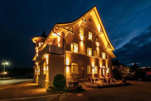a large building with lights on it at night at Landhotel Adler in Sigmarszell