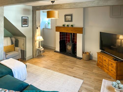 a living room with a fireplace and a tv at River View in Lazonby