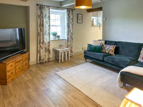 a living room with a couch and a flat screen tv at River View in Lazonby