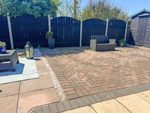 a patio with a couch and a chair in a backyard at The Lodge - Uk50721 in Aldbrough