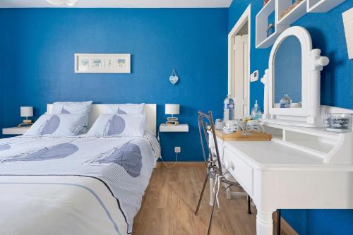 a blue bedroom with a bed and a white desk at Chambre Saint-Samson-Sur-Rance in Saint-Samson-sur-Rance