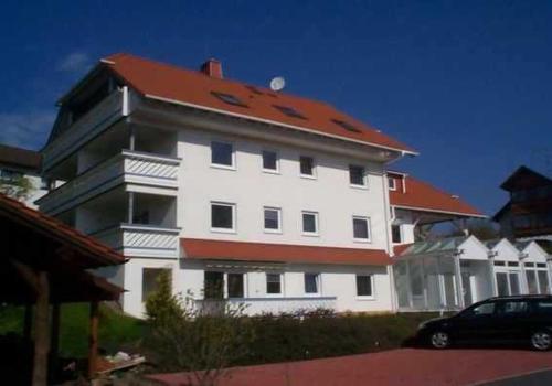 a large white building with a red roof at Ferienwohnung Haus Krüger in Hemfurth-Edersee